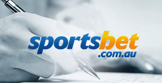 Hand hovering a pen above a piece of paper behind Sportsbet logo